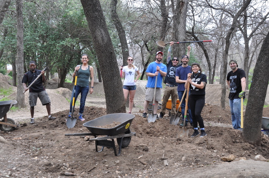 diverse volunteers removing dirt from around trees at Its my park day 3-3-18